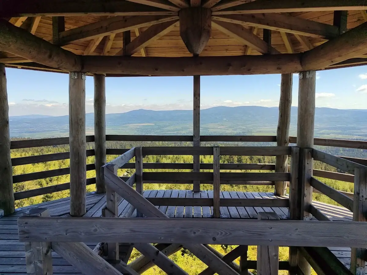 Zimowa panorama Sudetów widziana z wieży na Czerńcu – morze gór pod błękitnym niebem.