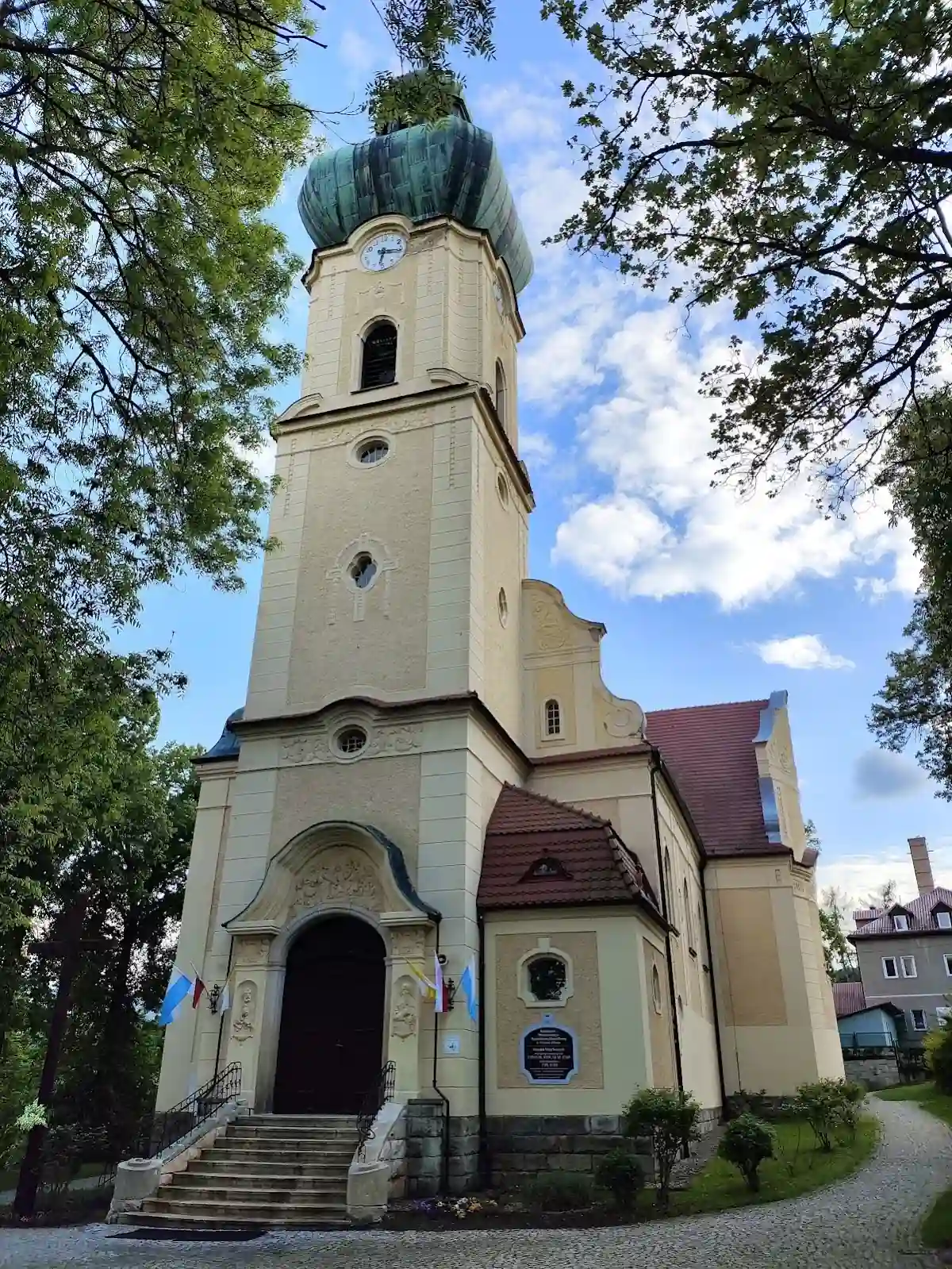 Tablica pamiątkowa na ścianie kościoła, świadek historii parafii.
