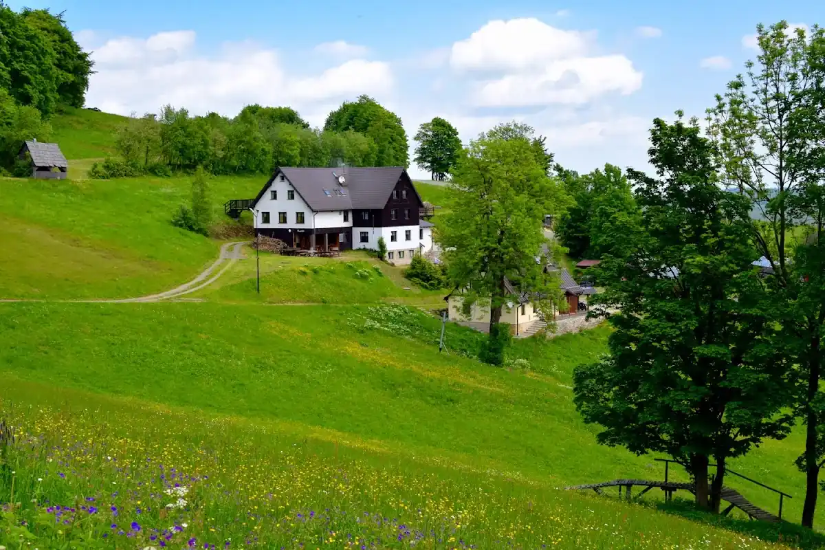 Narciarze i snowboardziści na orczyku przy ośrodku Mieszko w pełnym słońcu.