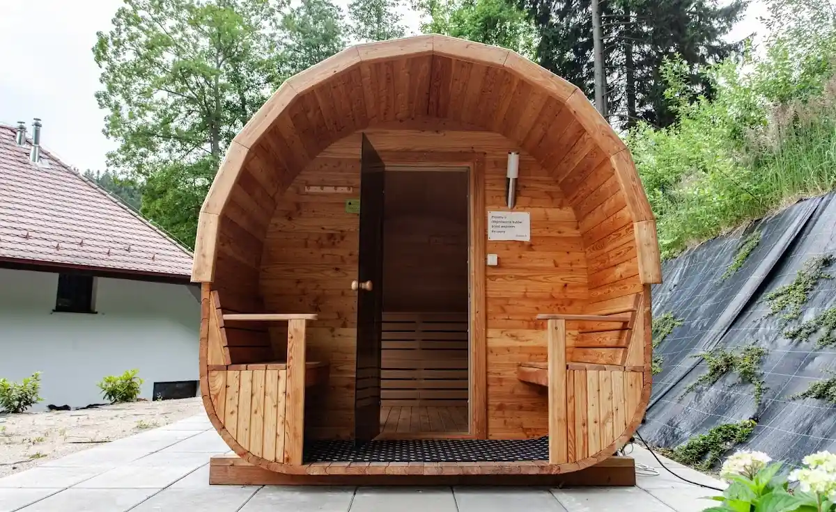 Drewniana sauna beczka w ogrodzie hotelowym zimą
