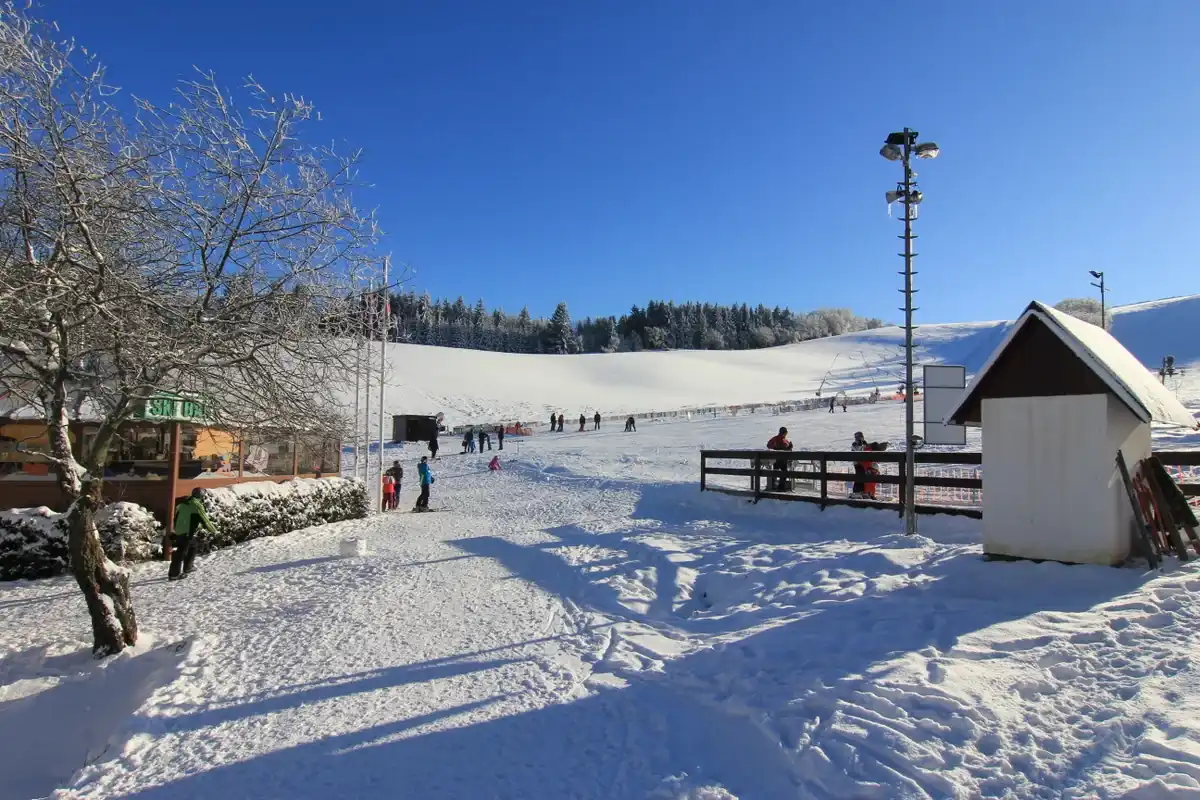 Widok na oświetlony stok w Olešnice po zmroku.