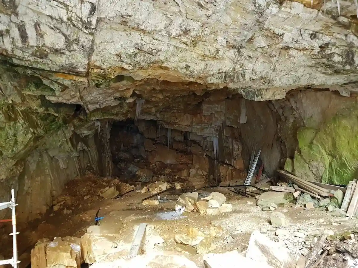 Wejście do małej jaskini skalnej pod niebem o świcie pod słońcem.