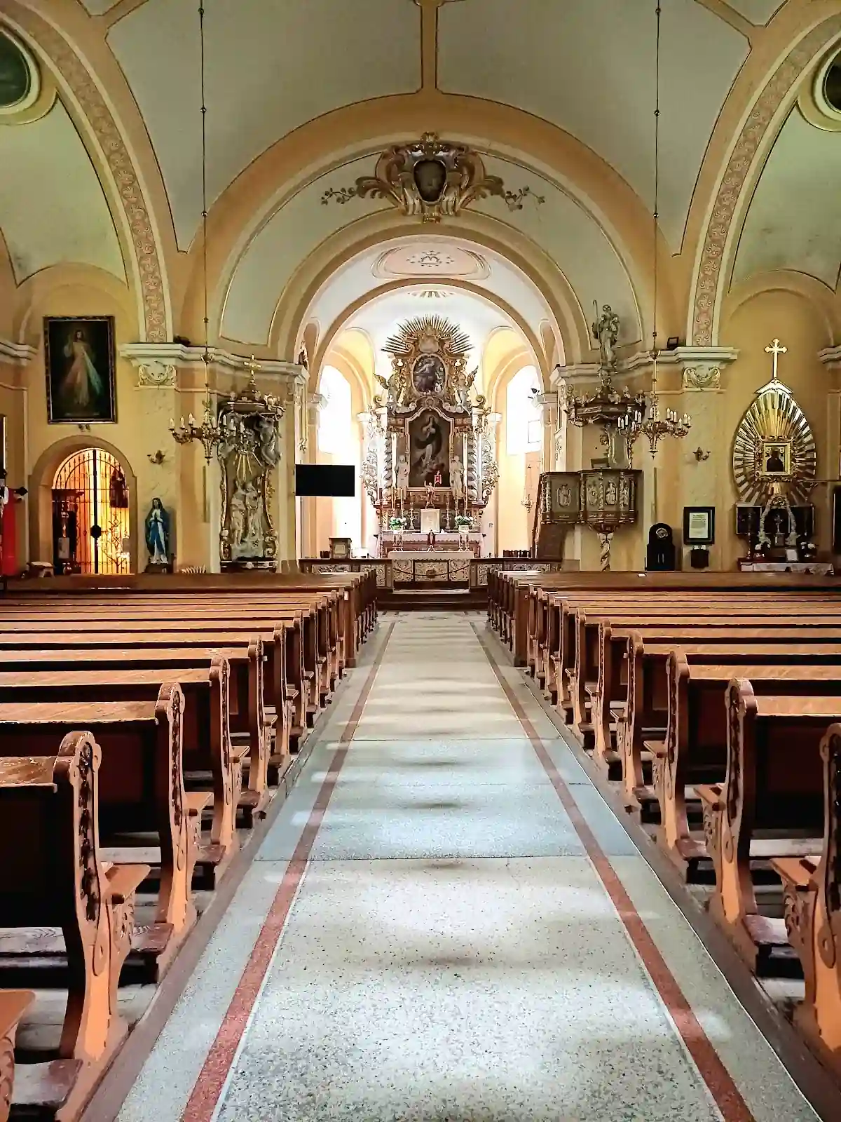 Bogato zdobiony ołtarzyk boczny pełen wotów, detal wnętrza.