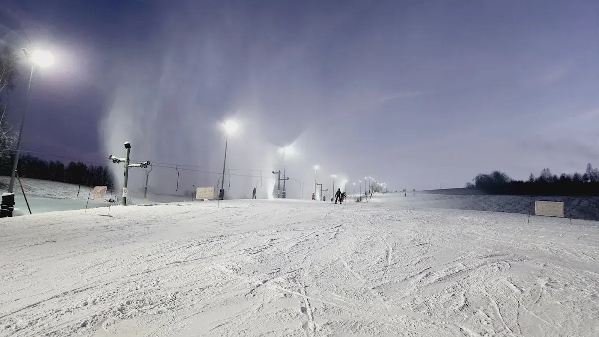 Narciarze przygotowujący się do zjazdu w promieniach zimowego słońca.