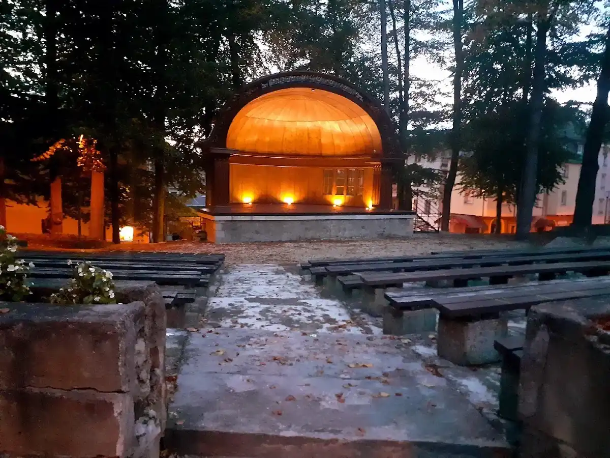 Biała altana Muszli Koncertowej w sercu lądeckiego parku zimą.