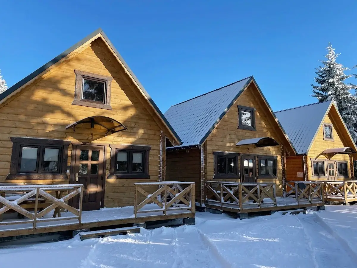 Zasypany śniegiem budynek ośrodka w Karłowie w pełnym, zimowym słońcu.