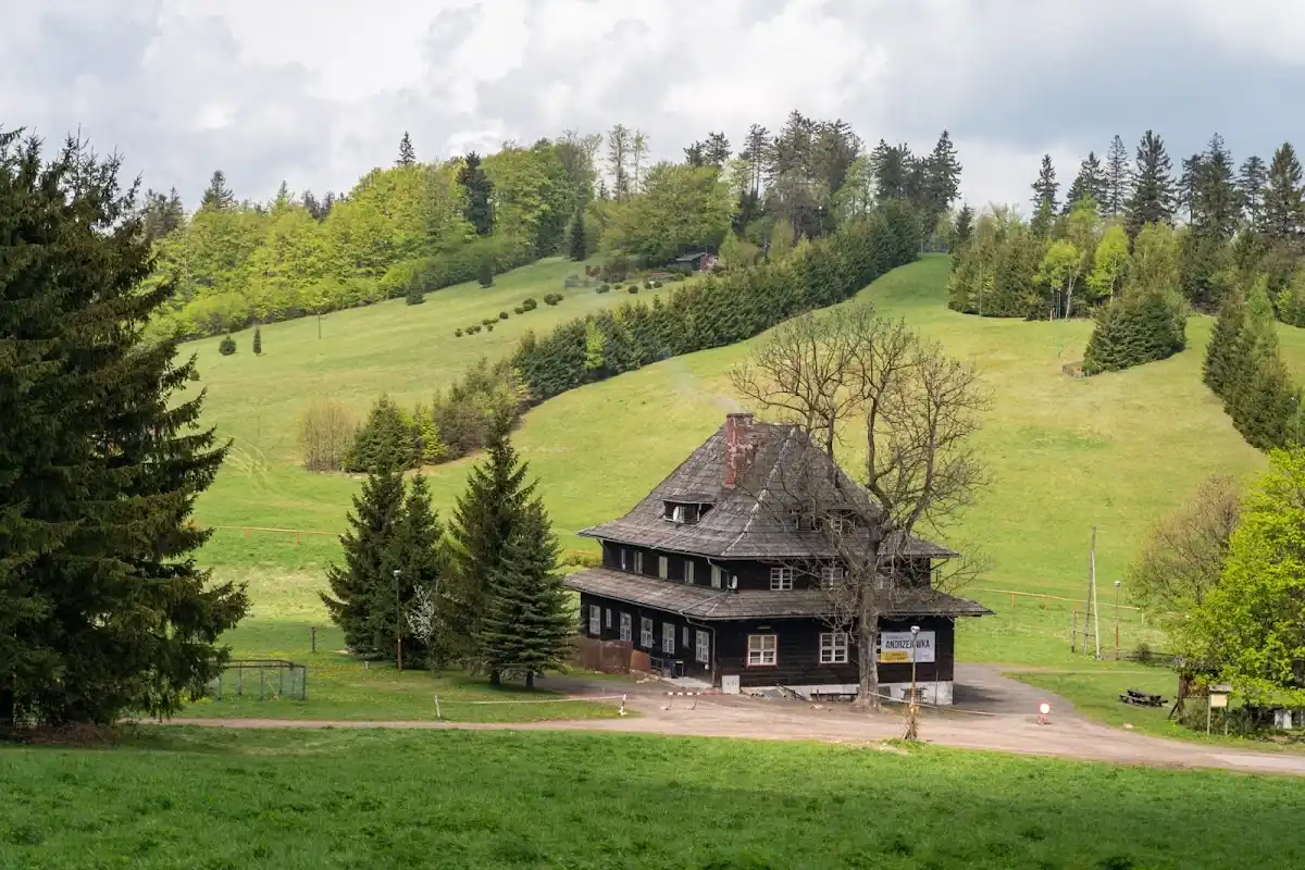 Oświetlone Schronisko Andrzejówka nocą w zimowej szacie.