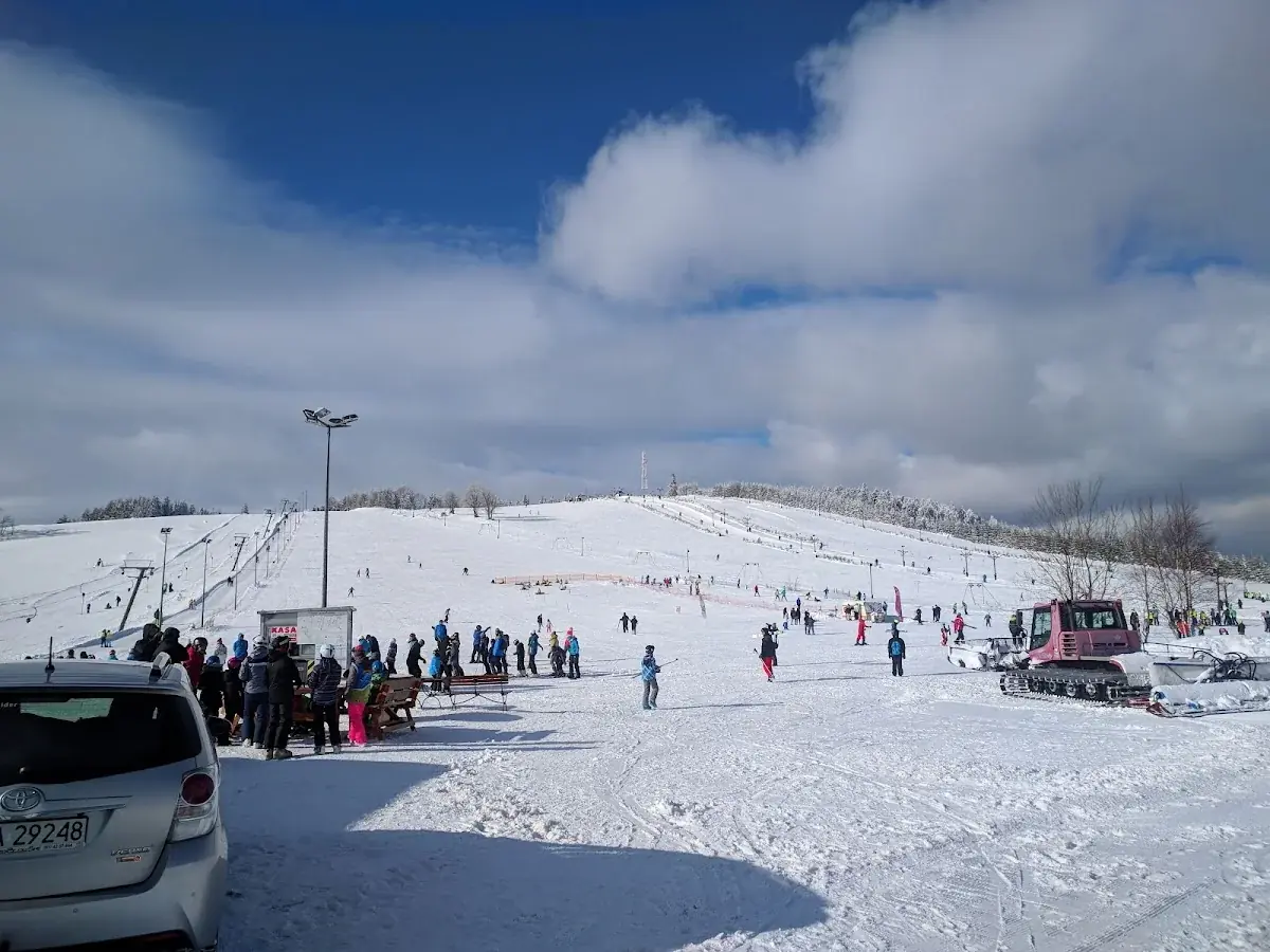 Stok narciarski na Przełęczy Sokolej tętniący życiem pod zimowym słońcem.