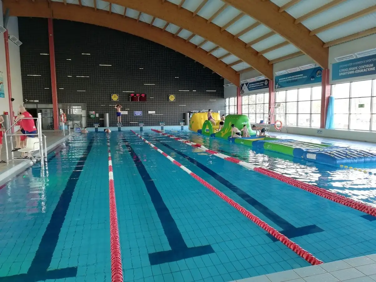 Lustro wody w basenie Aquaparku Granit, odbijające sufit i światła.