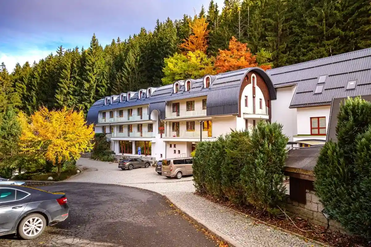 Zimowy widok na kompleks Jelenia Struga otoczony lasem.