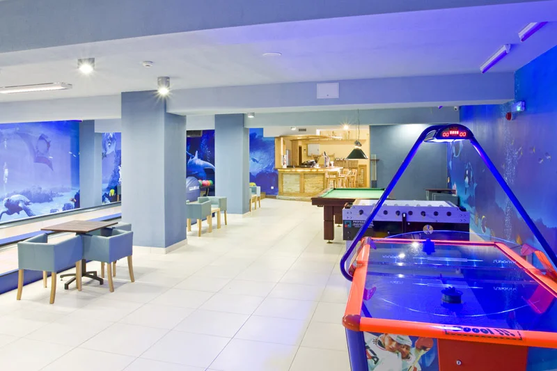 Nowoczesna sala rozrywki w hotelu – kręgle i bilard w oświetleniu.