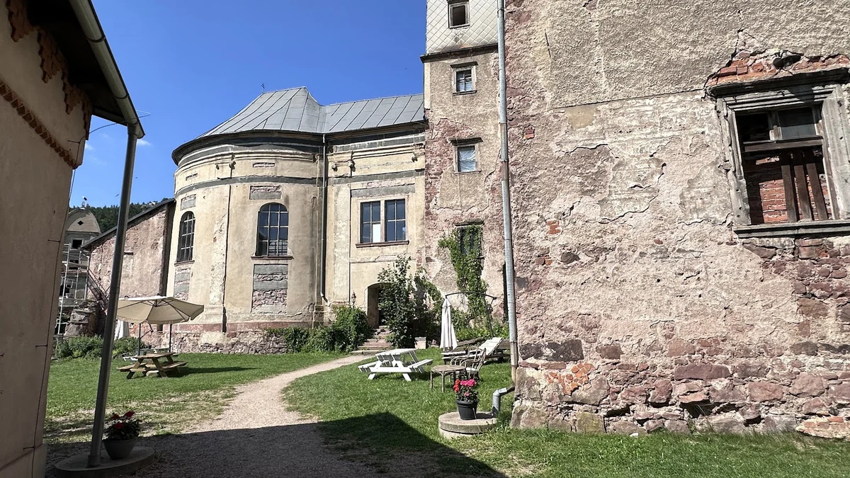 Stare mury pałacu z wieżą na tle błękitnego nieba.