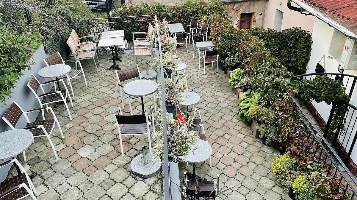 Taras widokowy ze stolikami na dziedzińcu zamku.