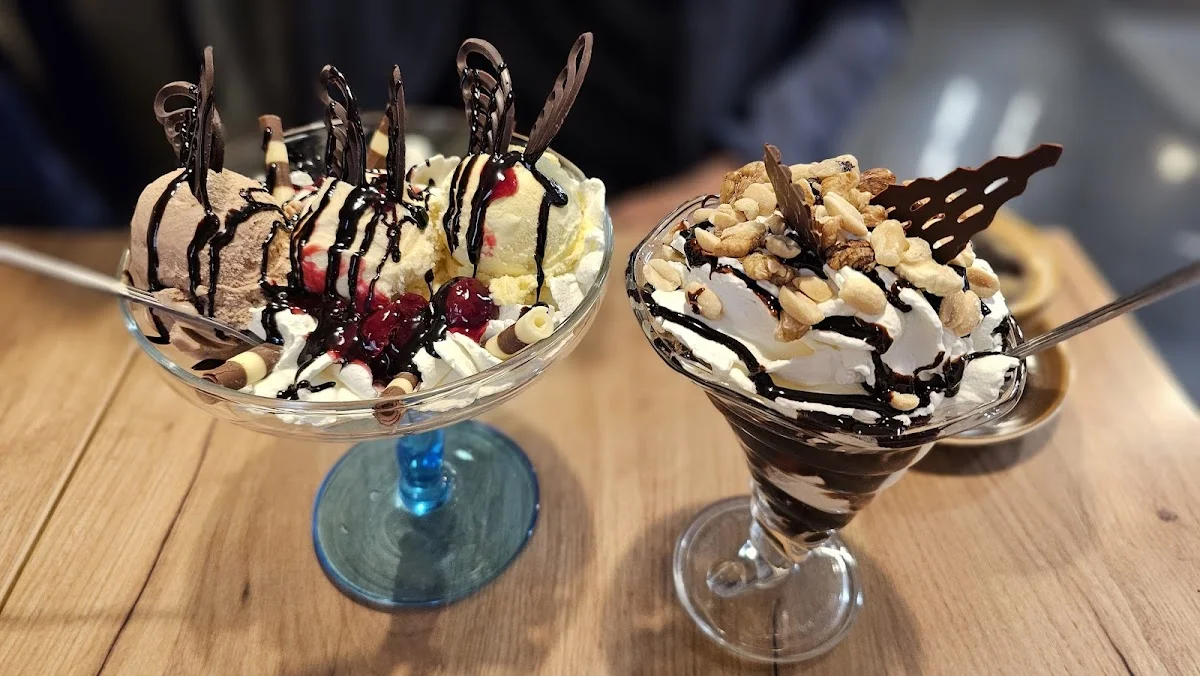 Dwa pyszne pucharki lodowe z owocami.