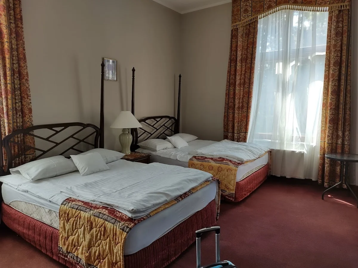 Łóżko małżeńskie w eleganckim pokoju hotelowym.