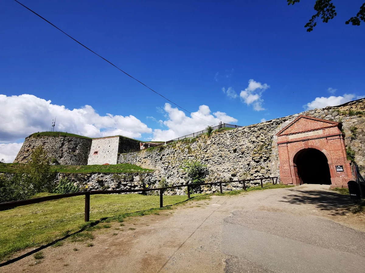 Panoramiczny widok na systemy fortyfikacyjne zamku o zachodzie słońca.