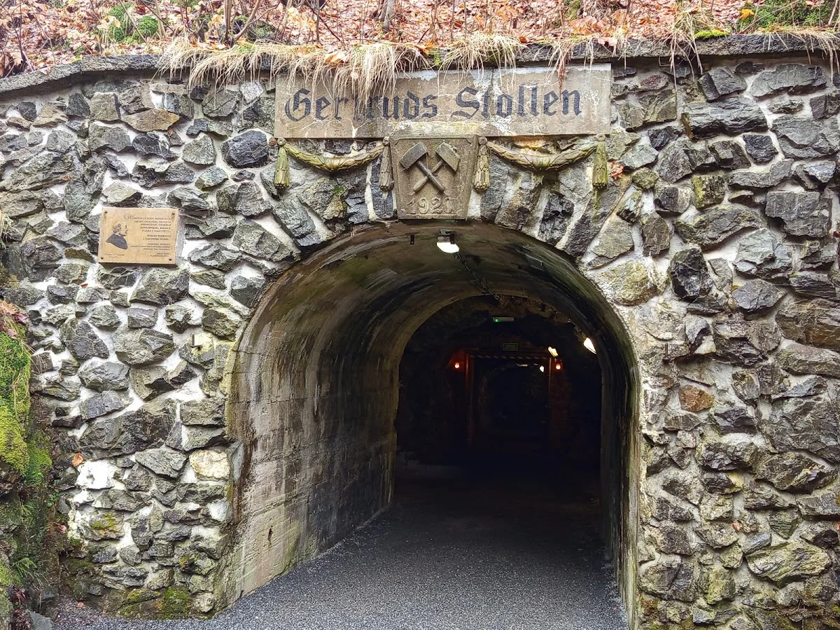 Mały budynek i wejście zabytkowe pod lasem o zachodzie słońca.