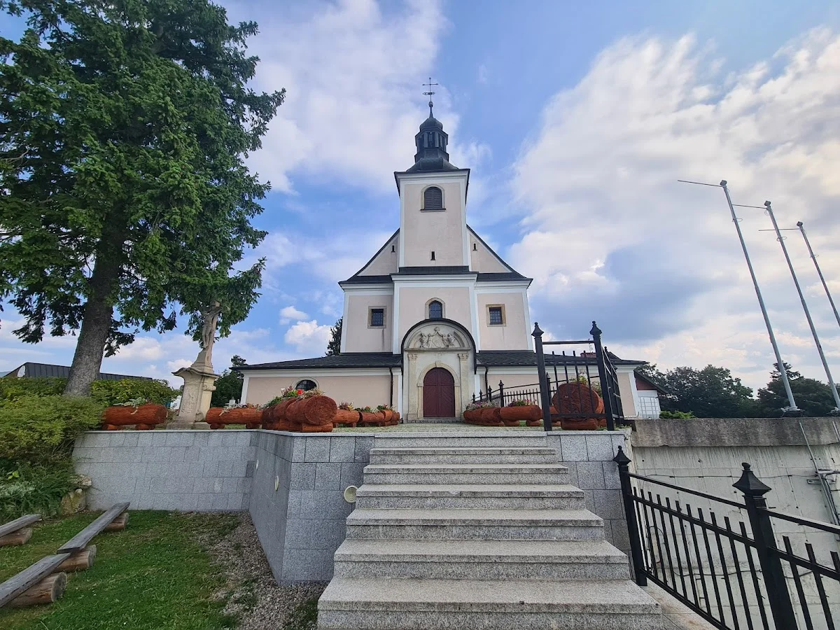 Mały kościół za metalowym ogrodzeniem pod niebem pod słońcem o świcie.