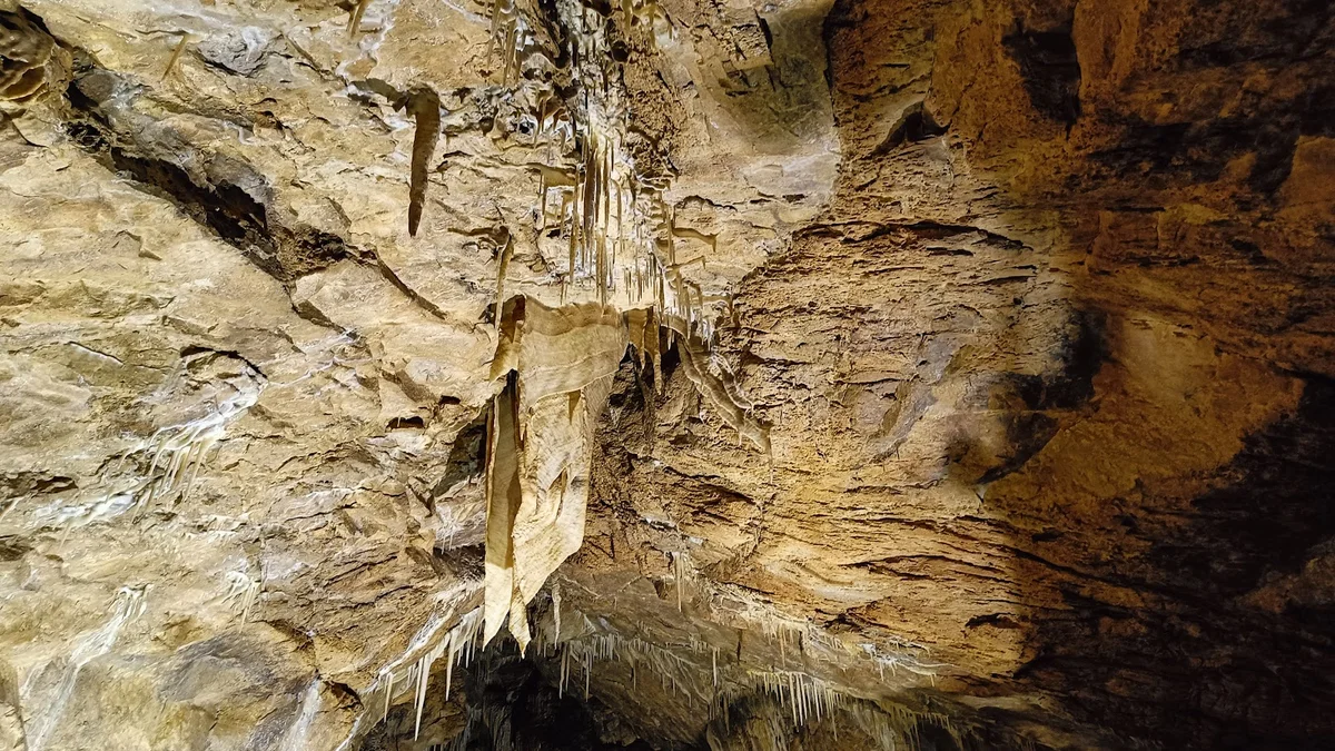 Formy krasowe na ścianach jaskini pod słońcem pod niebem o świcie.