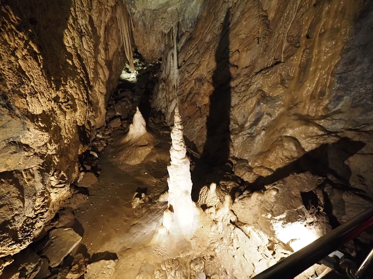 Potężny stalagmit w centralnej części jaskini pod słońcem o świcie.