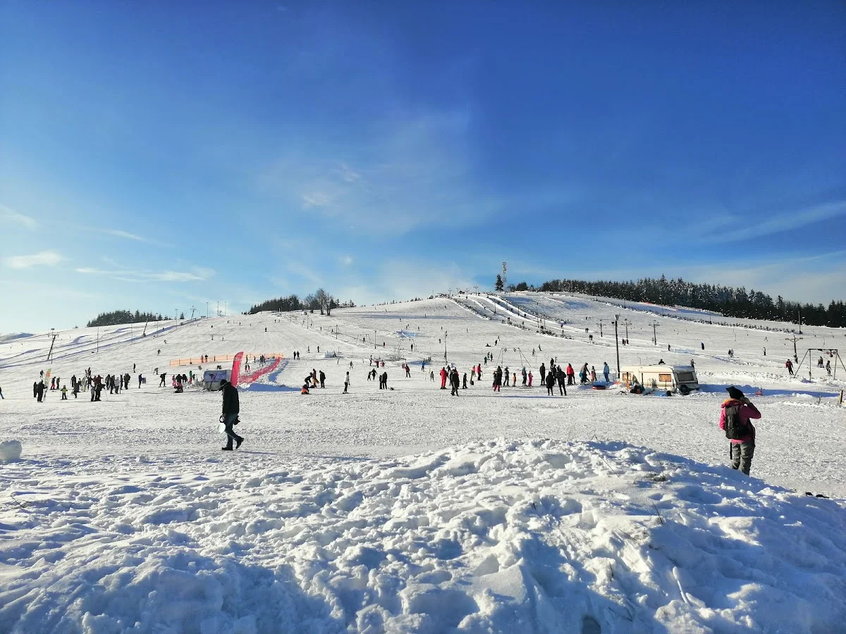 Stok narciarski pełen ludzi pod błękitnym niebem pod słońcem.