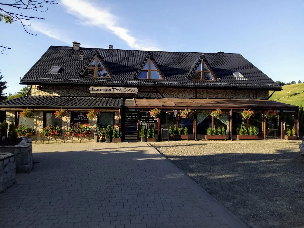 Nowoczesny budynek pensjonatu z dużym parkingiem.