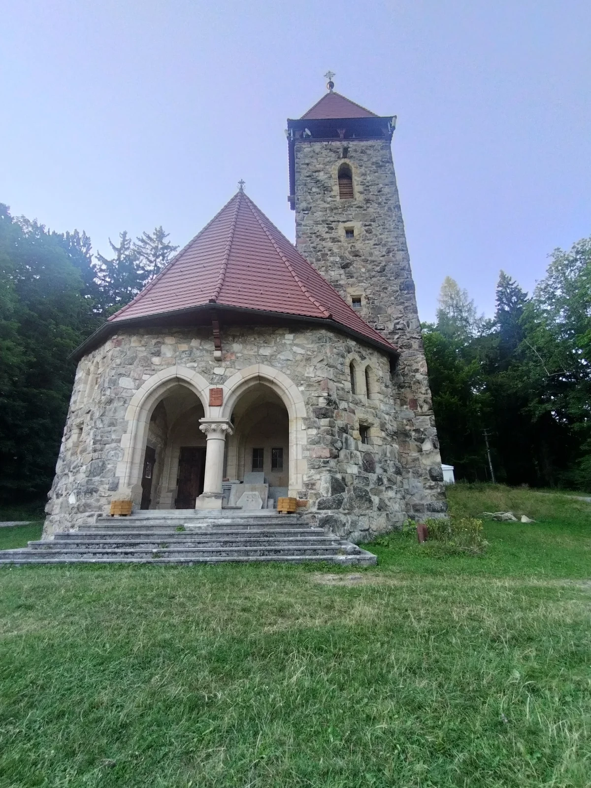 Mała kapliczka w lesie w słońcu.